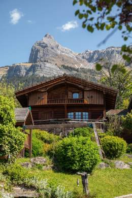 Chalet au pied de la montagne et de la verdure autour