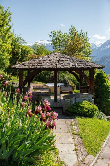 Fleurs, verdure et montagne autour d'un espace abrité