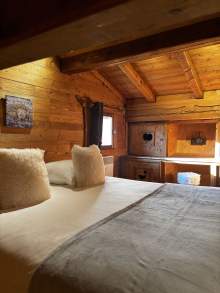 Lit double dressé dans un chalet